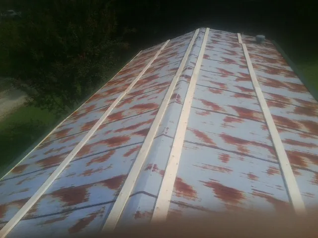 Rusted metal roof panels with new wood purlins before replacement — Storm Damage Roof Repair in Glencliff by Roofing Brothers
