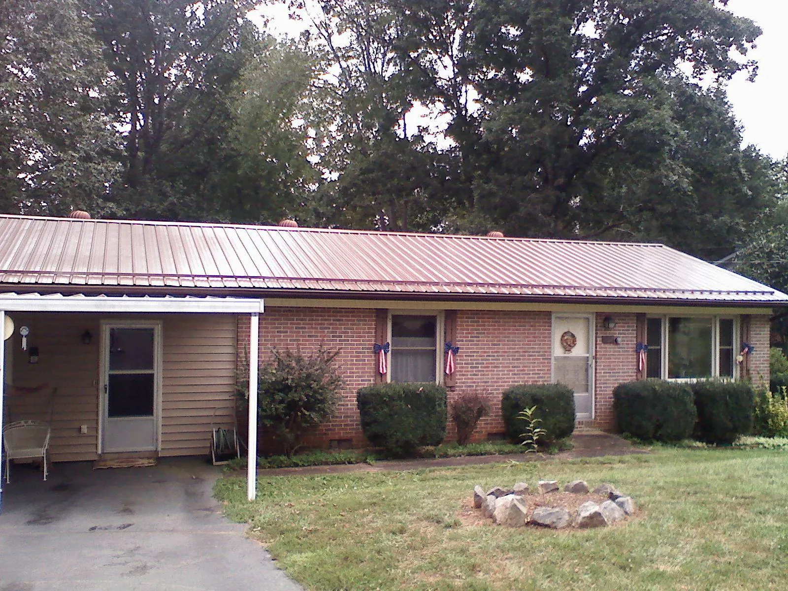 Bronze metal roof and carport on a brick ranch home — Roof Repair work by our crew in Glencliff